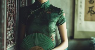 ChatGPT_AI提示词_一位年轻美丽的中国女性穿着青色丝质旗袍，优雅地站在一个阳光明媚的茶室里，手持绿色折扇_chatgpt会员值得买吗缩略图