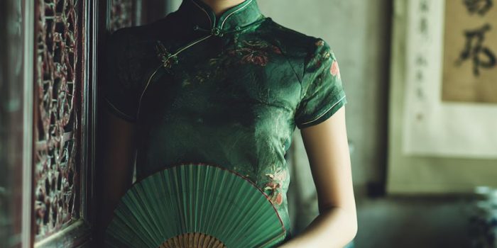 ChatGPT_AI提示词_一位年轻美丽的中国女性穿着青色丝质旗袍，优雅地站在一个阳光明媚的茶室里，手持绿色折扇_chatgpt会员值得买吗缩略图