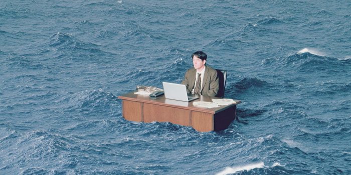 ChatGPT提示词_一个人坐在海中央的办公室桌前使用笔记本电脑_如何购买gpt会员缩略图