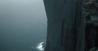 AI提示词_一个男孩穿着绿色圣诞毛衣，手中拿着咖啡，脸上挂着微笑，背景是星空和飘落的雪花_chatgpt会员版缩略图