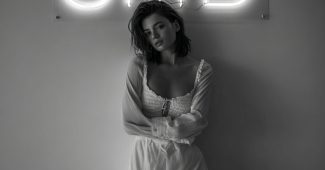 AI提示词_女性模特在专业拍摄中，背景是干净的白色墙壁和中心的霓虹字母’SMD’_gpt会员缩略图