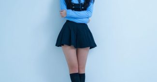 ChatGPT提示词_一位日本女孩穿着蓝色短裙服装，黑色长发，背景为简约白色工作室缩略图