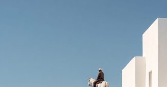 ChatGPT提示词_在圣托里尼一座全白建筑的屋顶上，牛仔骑马，呈现极简摄影风格_chatgpt5.2缩略图