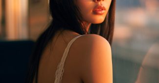 ChatGPT_AI提示词_年轻日本美人在火车窗边微笑，穿白色蕾丝背心，长直黑发，氛围温暖_chatgpt会员共享缩略图