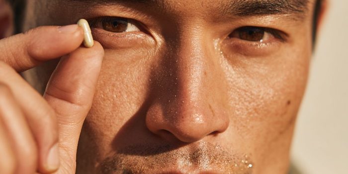 ChatGPT_AI提示词_一位英俊的亚裔男士在简单背景下举着一颗全白的胶囊_chatgpt国内接口缩略图