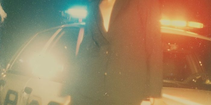 ChatGPT提示词_一位穿着黑色西装和裙子的摇滚风格女性自信地在夜晚的警车旁摆姿势_chatgpt会员有什么用缩略图