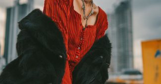 AI提示词_一位印尼年轻女子以电红色波波头和银色挑染大胆造型，穿着红条纹开衫裙搭配黑色高筒靴，表现出强烈自信_chatgpt在线试用缩略图