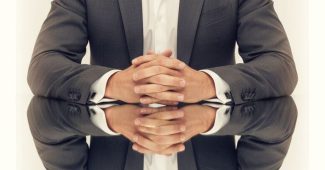 AI提示词_一位自信男士身着定制深灰色西装坐在反光玻璃桌前的对称肖像_chat gpt会员是智商税嘛缩略图