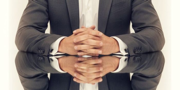 AI提示词_一位自信男士身着定制深灰色西装坐在反光玻璃桌前的对称肖像_chat gpt会员是智商税嘛缩略图