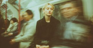 ChatGPT_AI提示词_一位30多岁的女性在伦敦地铁中平静坐着，周围的人都模糊不清，象征着在混乱中的宁静_chatgpt在线试用缩略图