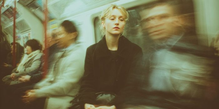 ChatGPT_AI提示词_一位30多岁的女性在伦敦地铁中平静坐着，周围的人都模糊不清，象征着在混乱中的宁静_chatgpt在线试用缩略图