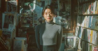 ChatGPT_AI提示词_一位穿着灰色高领毛衣和黑色中长裙的韩国女性在小型复古书店中，神情平静_chatgpt会员共享缩略图