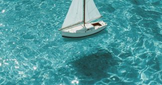 ChatGPT提示词_白色帆船在清澈的蓝水中漂浮_chatgpt5.0官网中文版缩略图