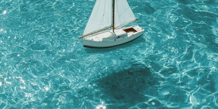 ChatGPT提示词_白色帆船在清澈的蓝水中漂浮_chatgpt5.0官网中文版缩略图