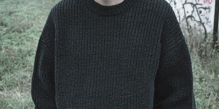 AI提示词_一位年轻瘦男士穿着宽松深灰色针织毛衣和深蓝色牛仔裤，目光坚定但略显疲惫，站在雾气笼罩的田野中_chatgpt5缩略图