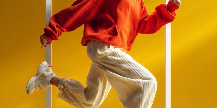 ChatGPT提示词_一名穿着红色连帽衫和奶油色长裤的女性充满活力地走出框架_gpt会员充值缩略图