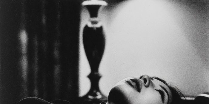 ChatGPT提示词_一位27岁的日本女性在现代酒店房间的床上侧卧，穿着黑色高领上衣，目光专注于一盏灯_chat gpt会员共享缩略图