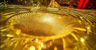 ChatGPT提示词_碎玻璃片掉入液态黄金中，形成波纹和抽象的波浪_chatgpt官网网页版缩略图