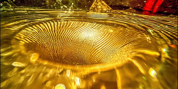 ChatGPT提示词_碎玻璃片掉入液态黄金中，形成波纹和抽象的波浪_chatgpt官网网页版缩略图