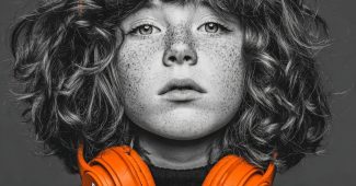 ChatGPT提示词_一个年轻女孩佩戴着亮橙色耳机，背景是黑暗的单色调_chatgpt官网中文缩略图