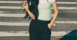 ChatGPT提示词_一位年轻的韩国女性正在自信地涂抹唇彩，穿着白色短袖T恤和薄纱薄绿背心，搭配黑色宽腿裤，展现出强烈的轮廓感_gpt会员多少钱缩略图