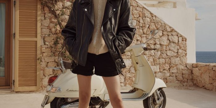 ai提示词_一位欧洲女性模特身穿黑色皮夹克和米色针织毛衣，搭配黑色迷你短裤和豹纹鞋，站在地中海的奢华度假酒店前_gpt会员多少钱缩略图