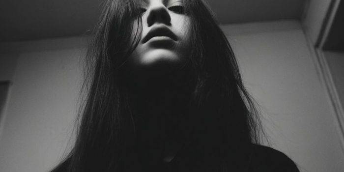 Ai提示词_一位留长发的人穿着黑色衬衫在顶光下的低调氛围中静立_国内如何买gpt会员卡便宜缩略图