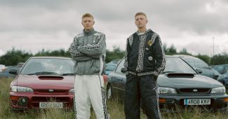 AI提示词_两位穿着带有传统爱尔兰花纹运动服的爱尔兰男子，站在贝尔法斯特郊外的田野里，身后是他们的斯巴鲁汽车_国内如何买gpt会员卡便宜点缩略图