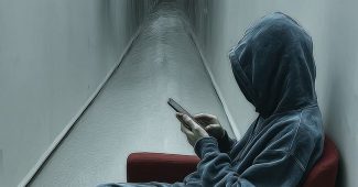 Ai提示词_一个穿着蓝色卫衣的男人坐在现代红色椅子上，侧身使用手机缩略图